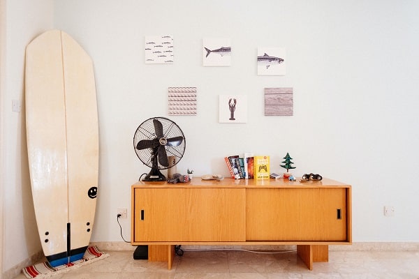 a surfboard and fan inside a room